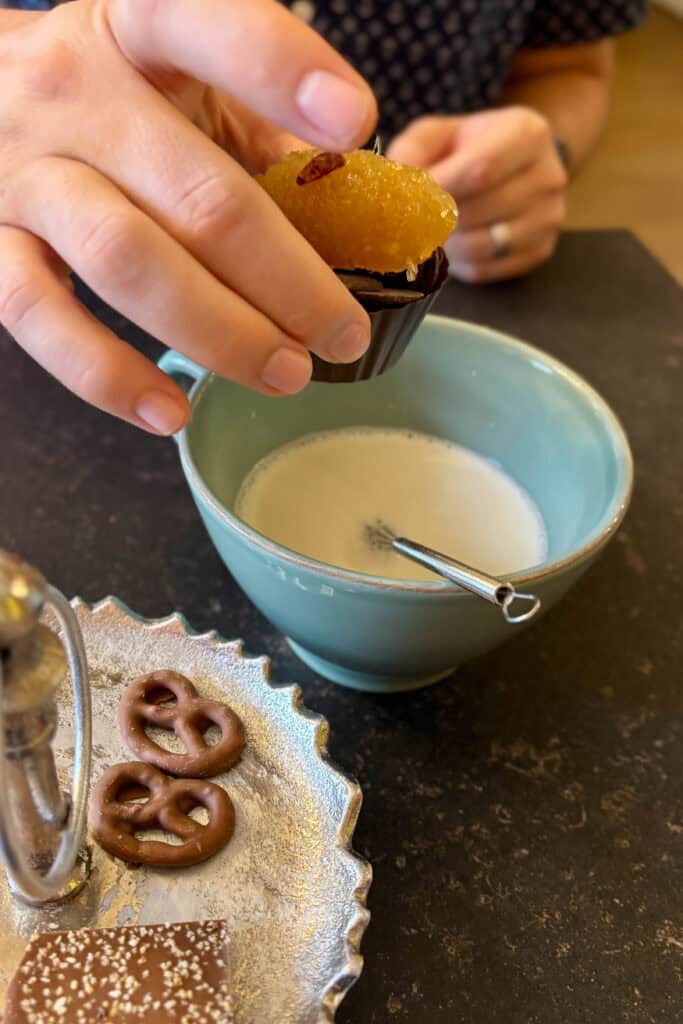 Adding chocolate and chili peppers to cup of warm milk.