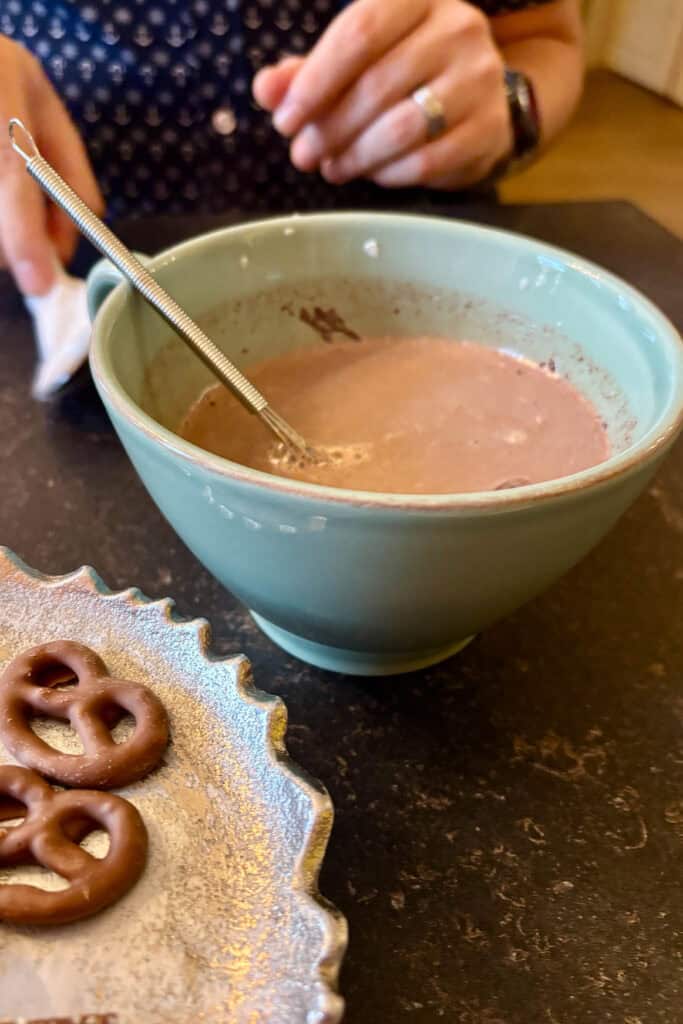 Cup of hot chocolate with small whisk.