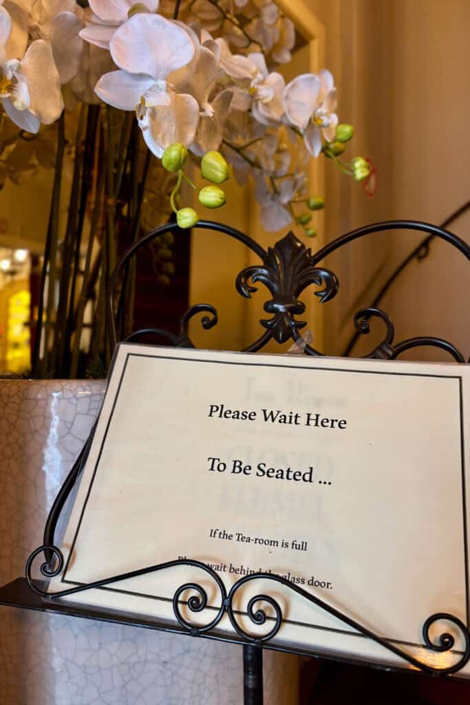 Sign instructing guests to wait to be seated.