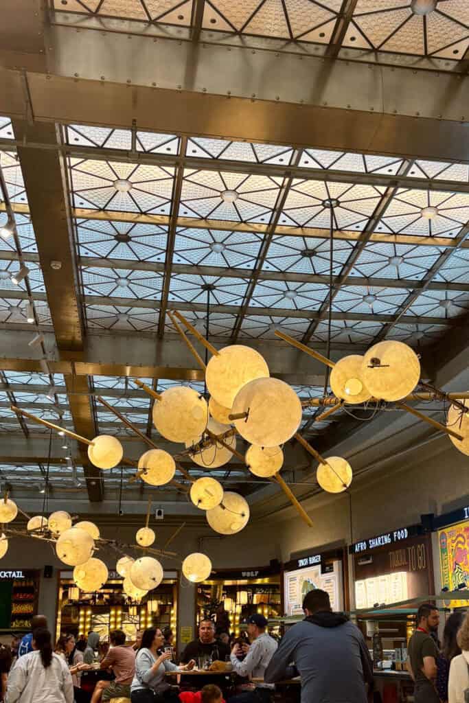 Indoor dining area at Wolf Market with chandeliers made with yellow orbs.
