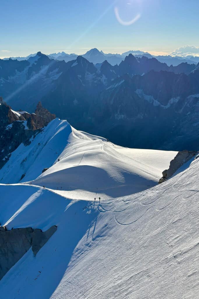 Distant view of mountaineers traversing snowy ridge.