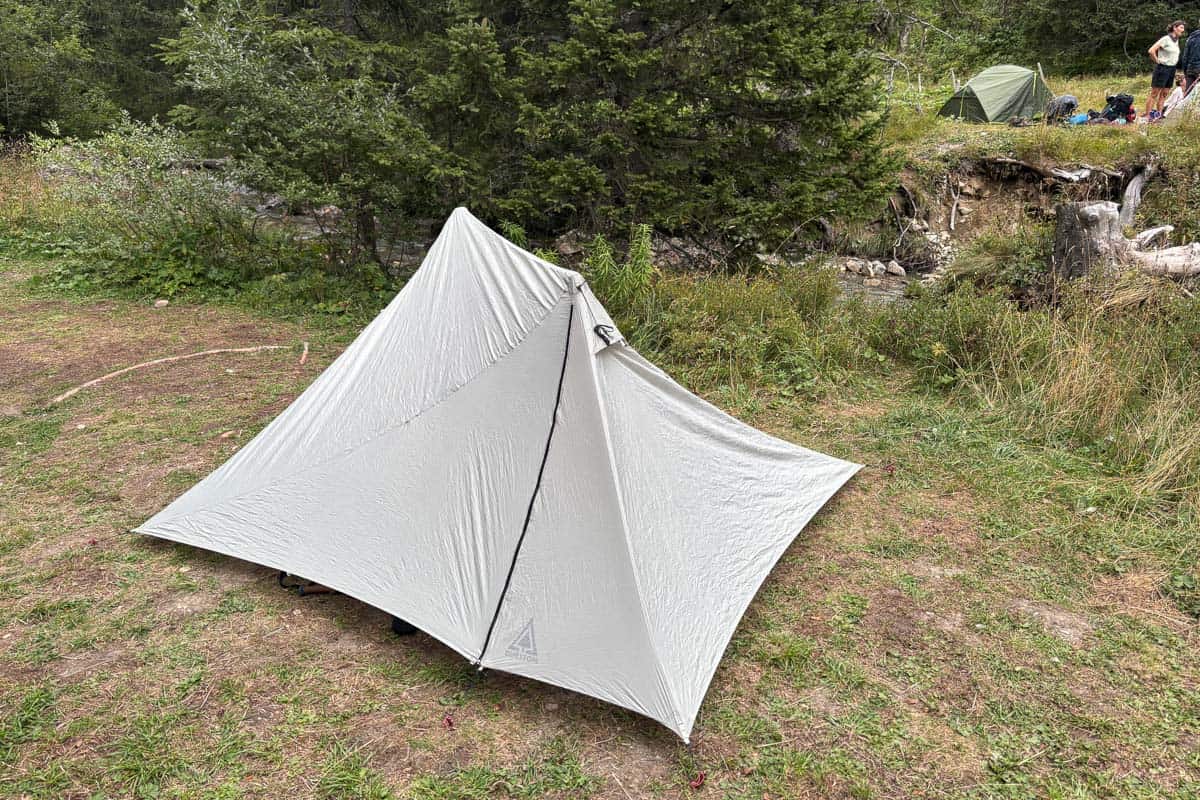 Small backpacking tent erected on flat ground while camping the Tour de Mont Blanc.