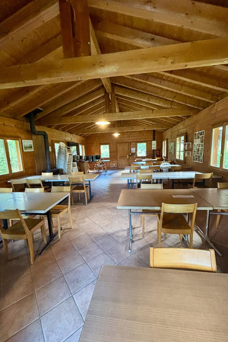 Tables and chairs at indoor shelter at Camping des Glaciers.