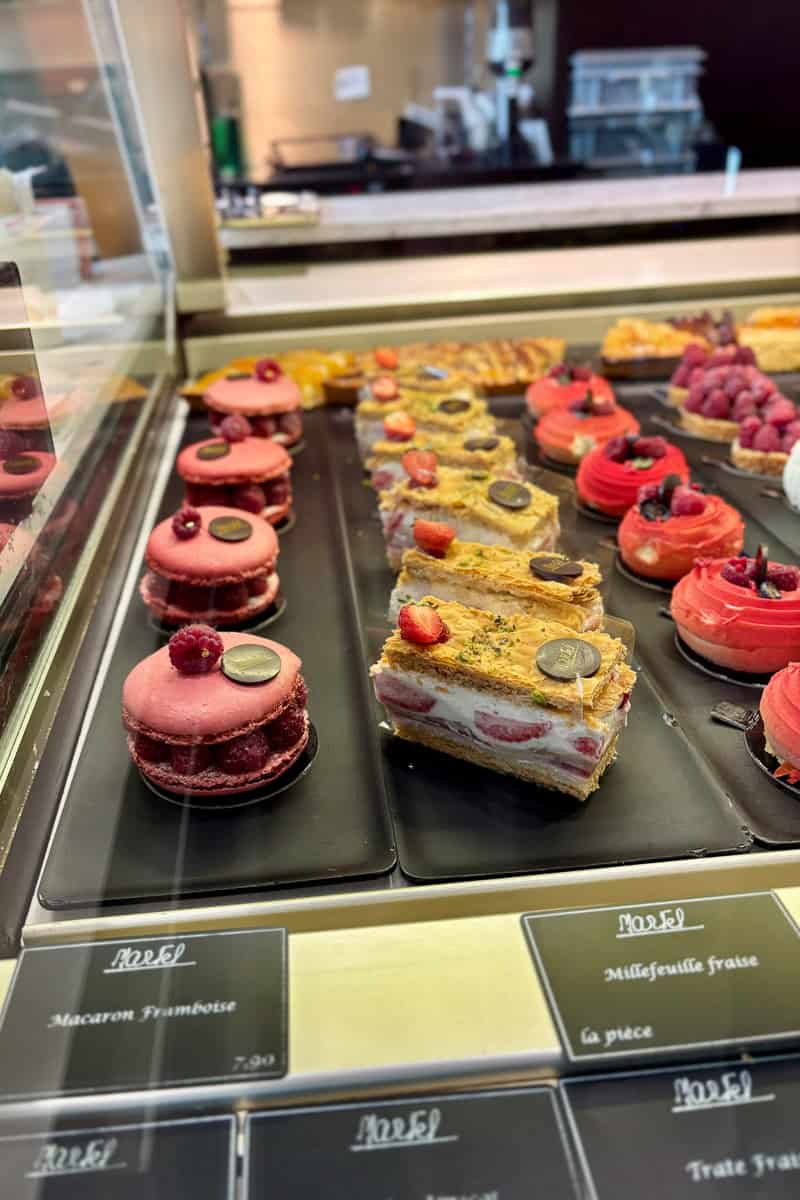 Raspberry macarons and strawberry millefeuille on display.