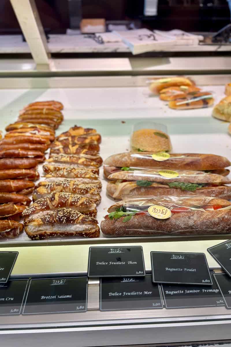 Baguette sandwiches and salami pretzels on display.