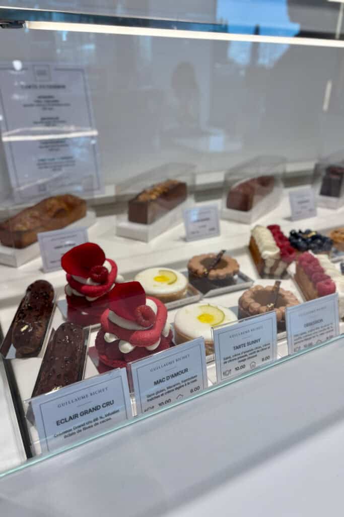 Eclairs, macarons, and tarts on display.