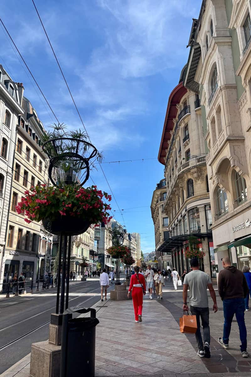 Street scene in Geneva with pedestrians strolling in shopping district.
