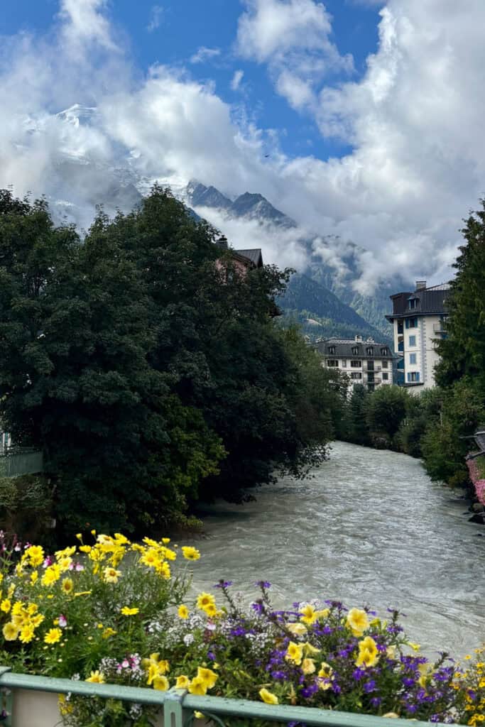 River through Chamonix with cloud-covered mountain peak in background.