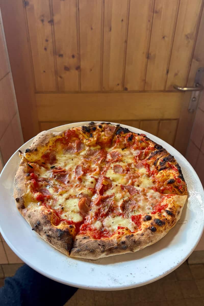 Pizza topped with ham.