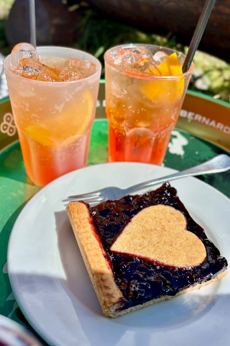 Two glasses of aperol spritz and slice of blueberry pie, choices we found among the best food and drink on the Tour du Mont Blanc.