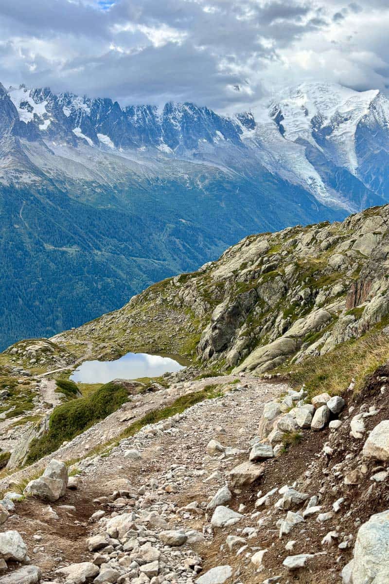 Rocky trail with view of snow-covered mountain range.