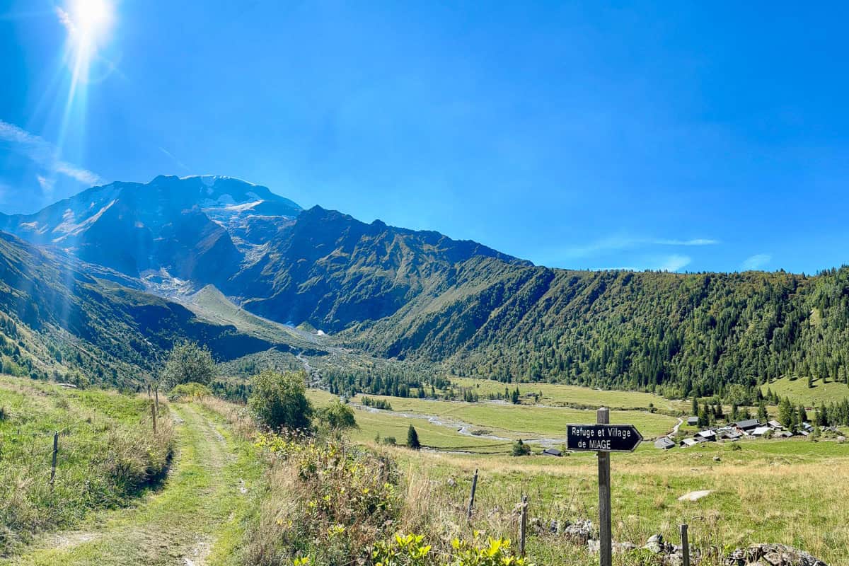Alpine valley with sign for Refuge et Village de Miage.