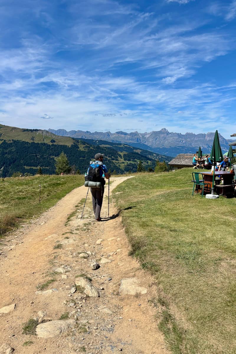 Backpacker on level dirt path on Stage 1 of the Tour du Mont Blanc.
