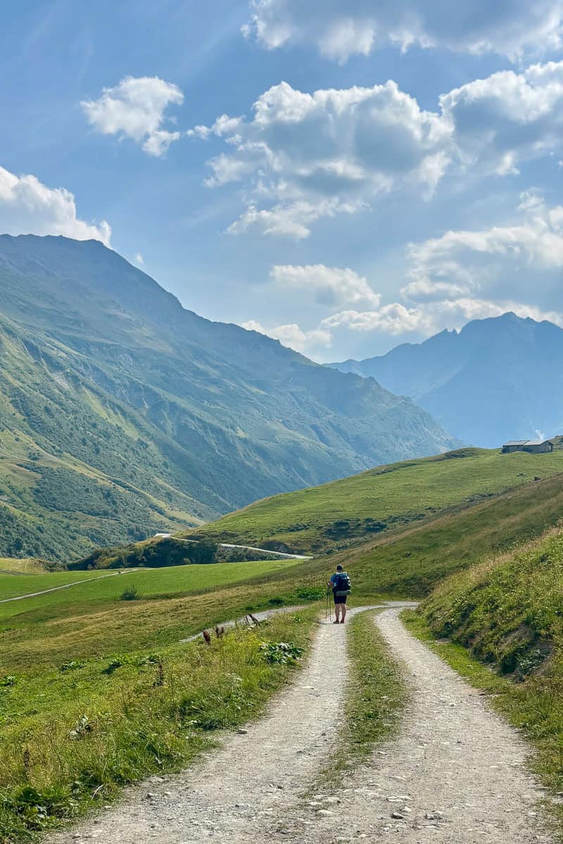 Backpacker on trail through Alpine mountain scenery on Stage 2 of the Tour du Mont Blanc.