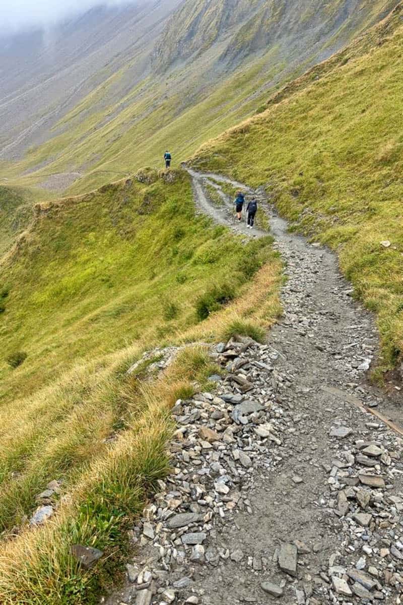 Gravel trail along foggy mountainside.
