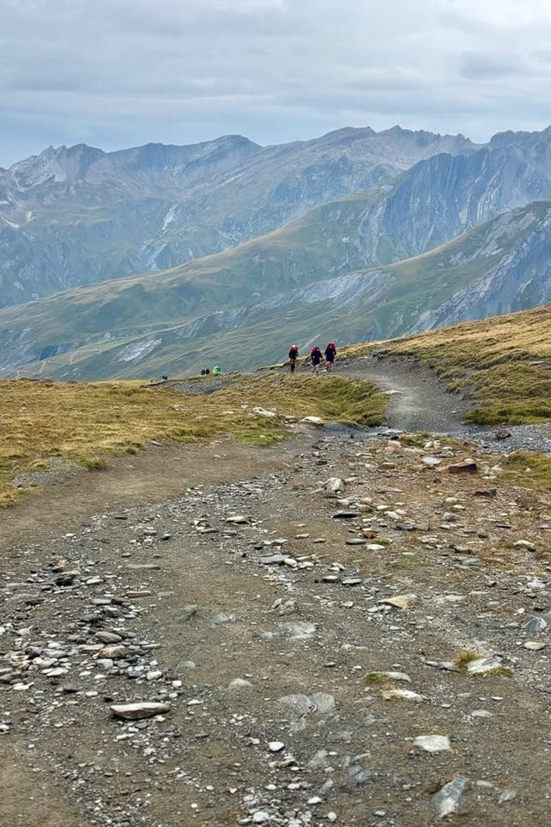 Dirt and gravel trail with sloping mountains in background.