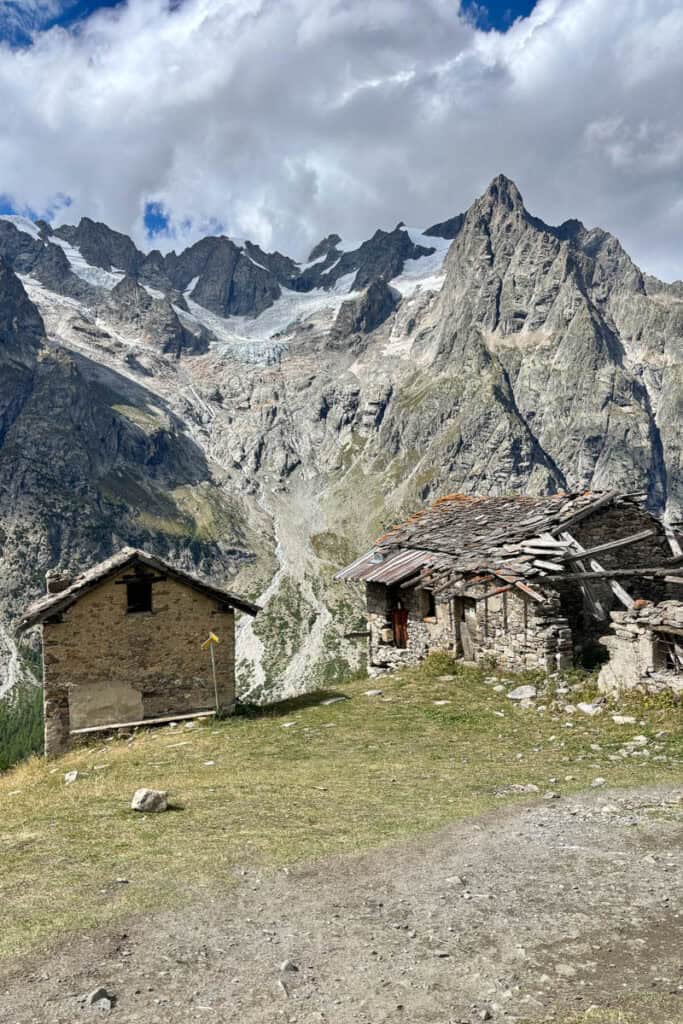 Old stone outbuildings perched on edge of mountainside.