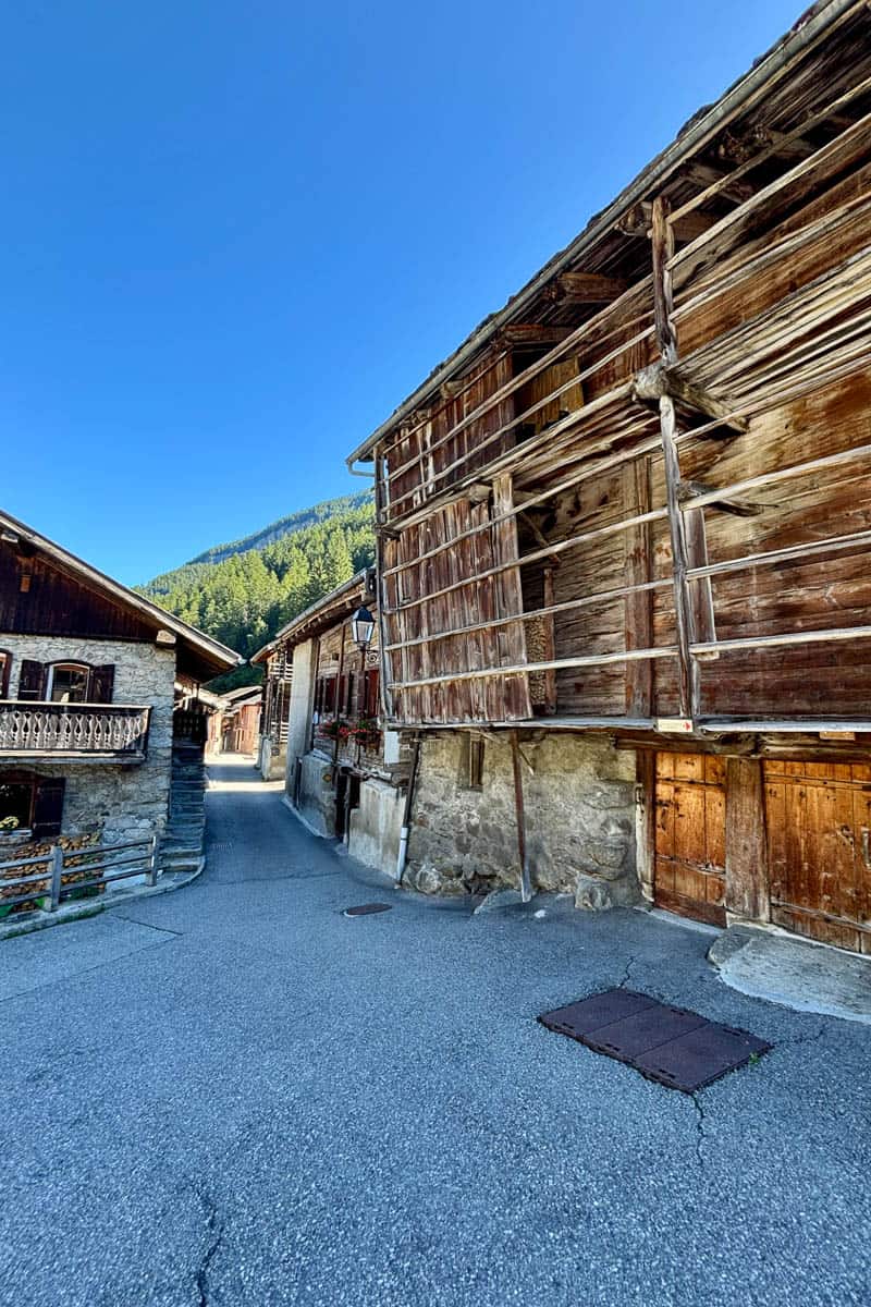 Timber and stone buildings on village street.