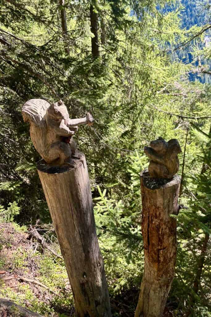 Wooden squirrel sculptures alongside trail.