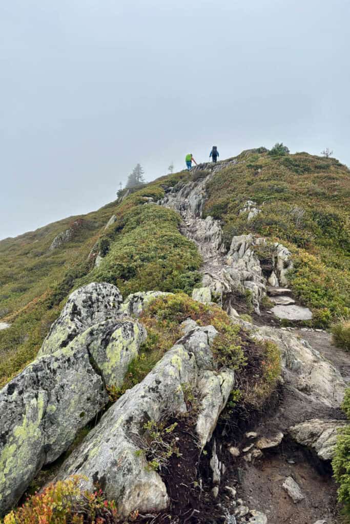 Distant hikers nearing the top of a rocky ascent.