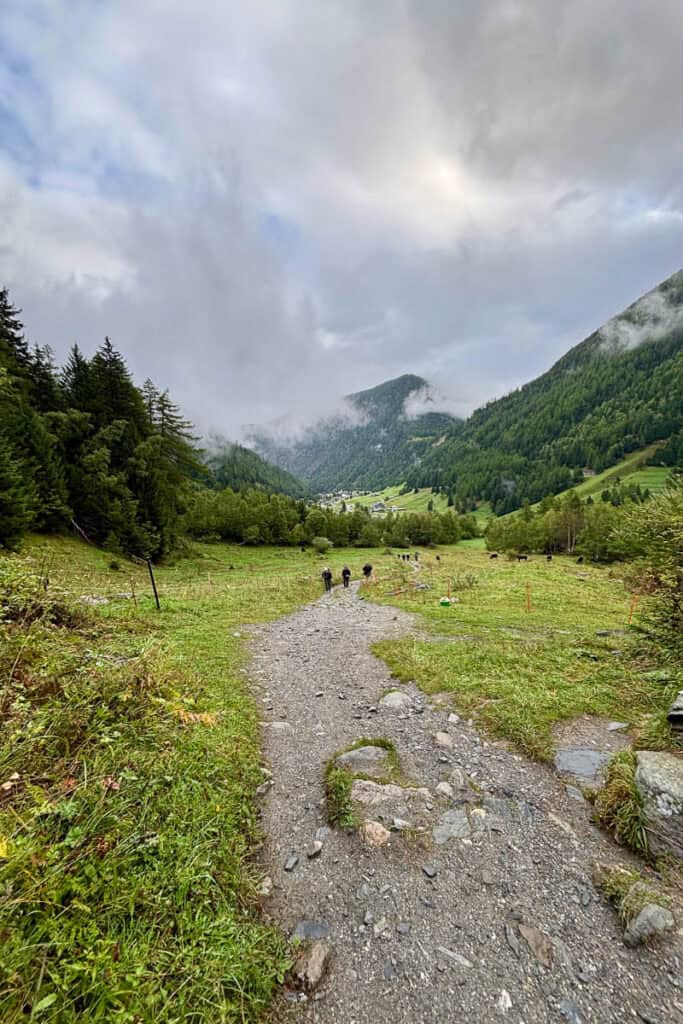 Hikers on gravel trail beginning Stage 9 of the Tour du Mont Blanc.
