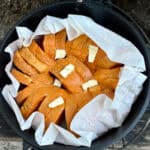 Slices of French toast topped with pats of butter in dutch oven.