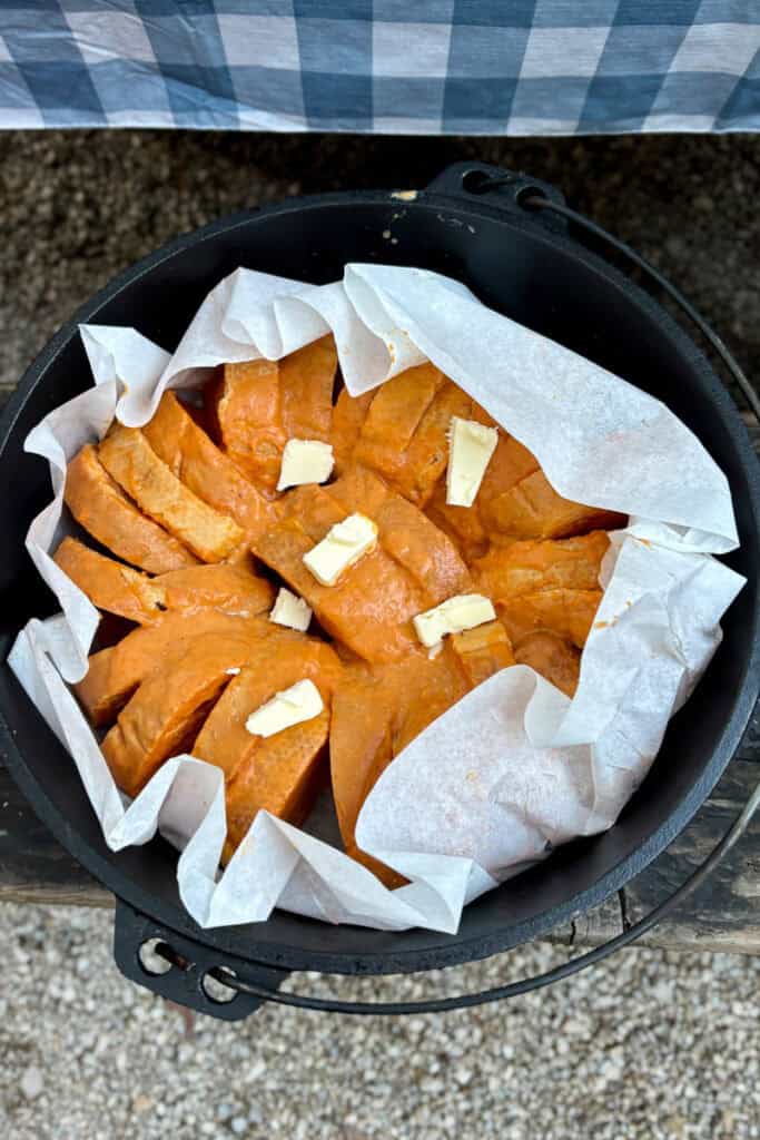 Slices of French toast topped with pats of butter in dutch oven.