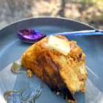 Plate of campfire baked French toast topped with butter and syrup.