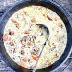 Cast-iron dutch oven filled with campfire creamy chicken soup.