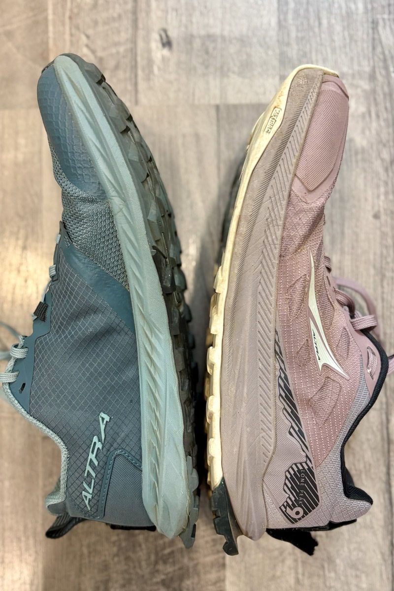 Side view of Altra Superior and Altra Lone Peak trail runners with soles facing each other.