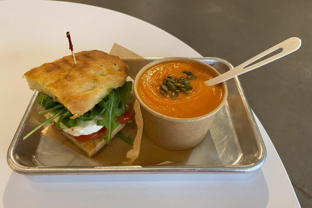Pesto caprese sandwich and cup of coconut carrot soup.