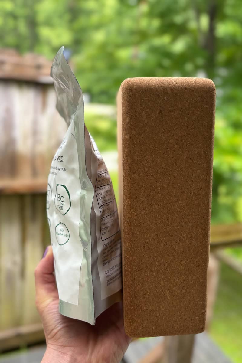 Package of freeze dried food held next to yoga block to compare thickness.