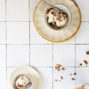 Bowls of bourbon ice cream with chocolate swirl topped with pecans.