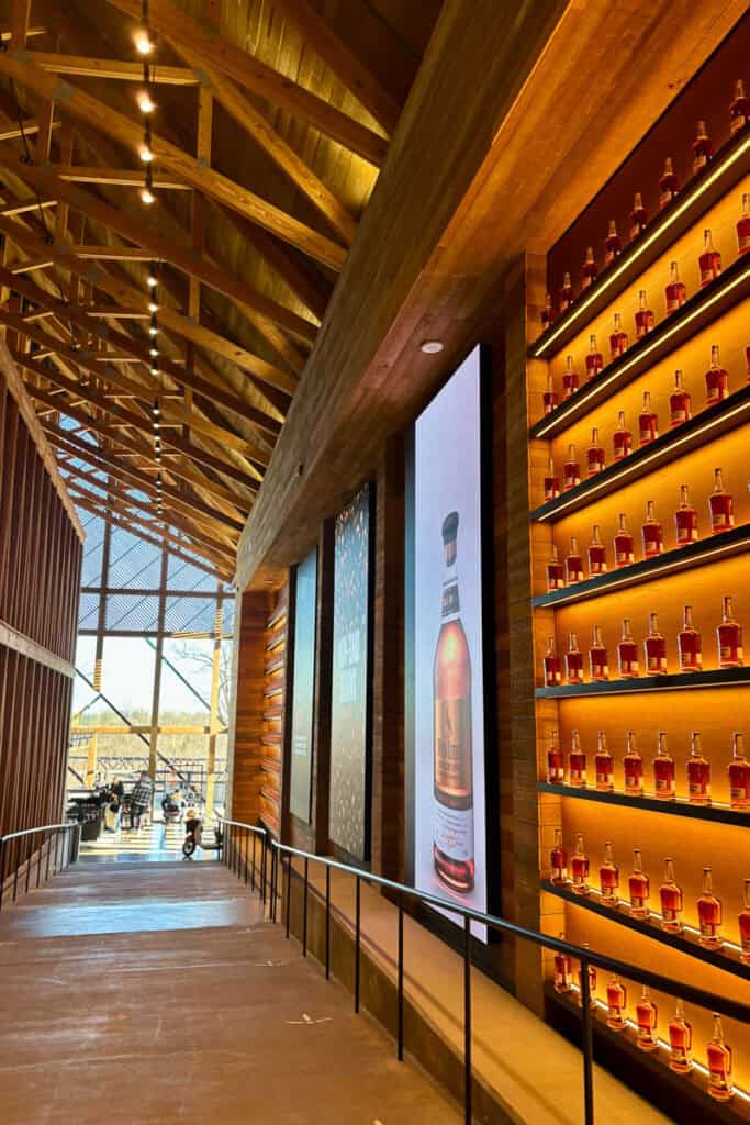 Walkway inside Wild Turkey visitor area, with bourbon bottles in a lighted display on the wall.