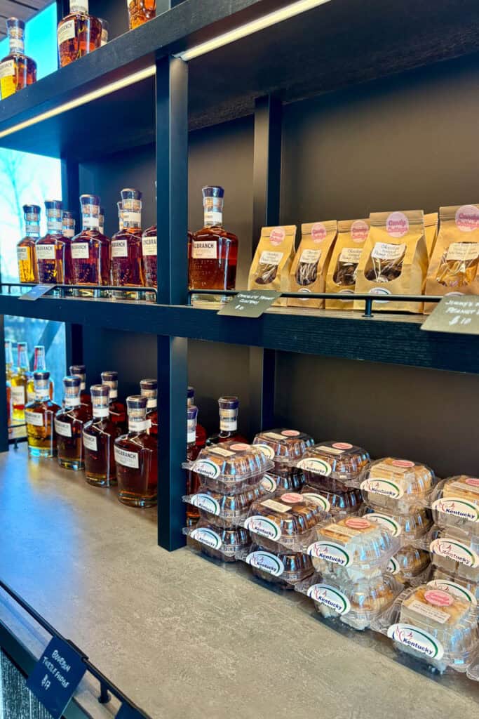 Packages of bourbon fudge for sale next to bottles of bourbon.