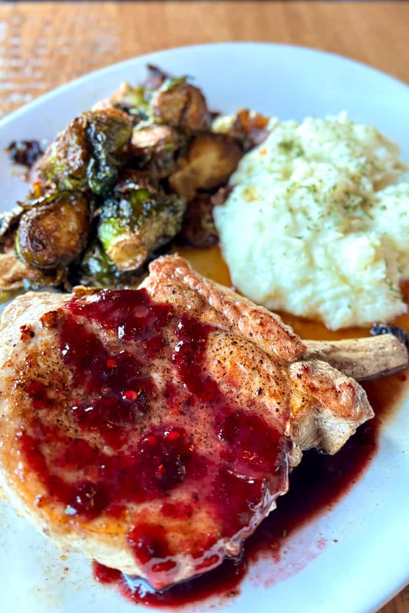 Double-cut bone in pork chops with blackberry glaze, brussels sprouts and mashed potatoes.