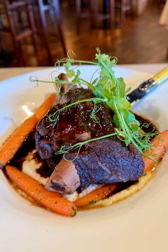 Lamb shank served with carrots and polenta.