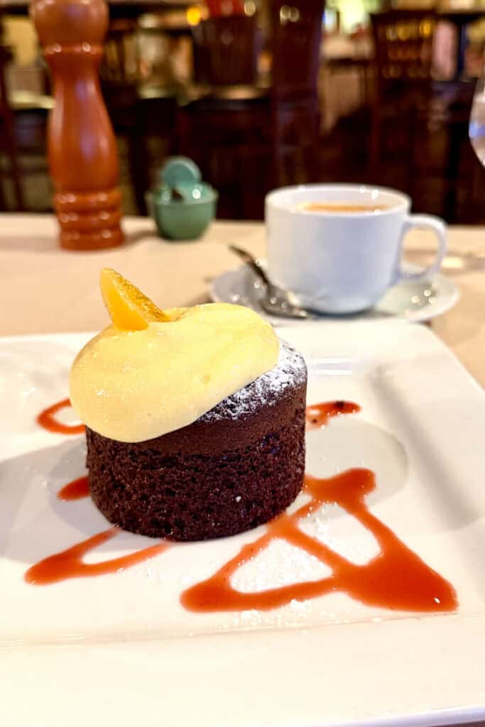 Small round flourless chocolate cake with cream topping.