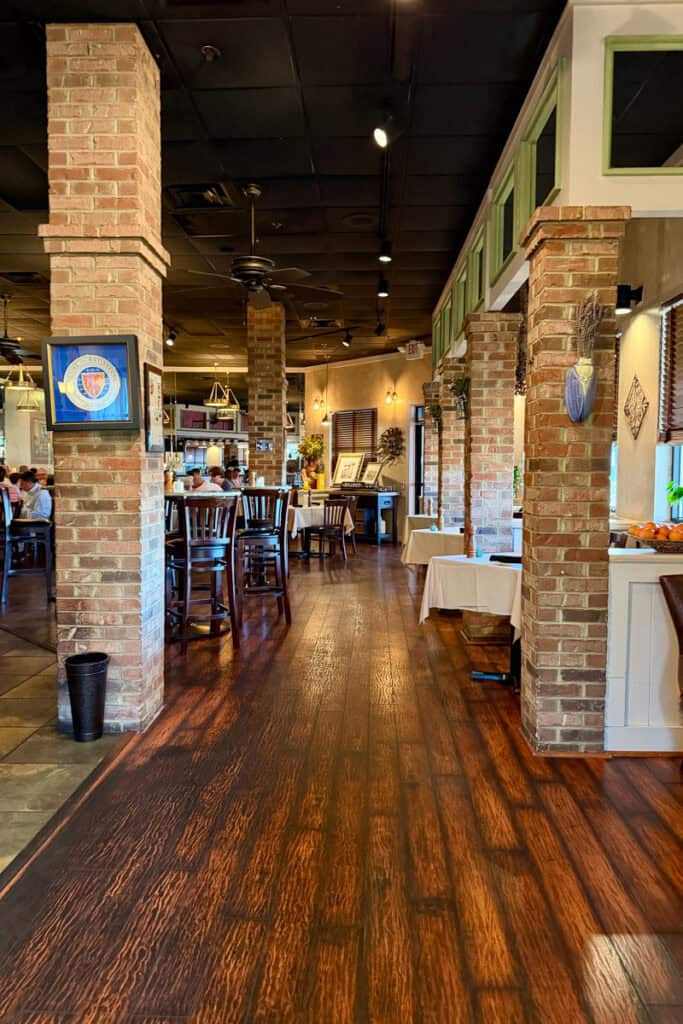 Indoor dining area of Brasserie Provence, with evenly spaced brick pillars.