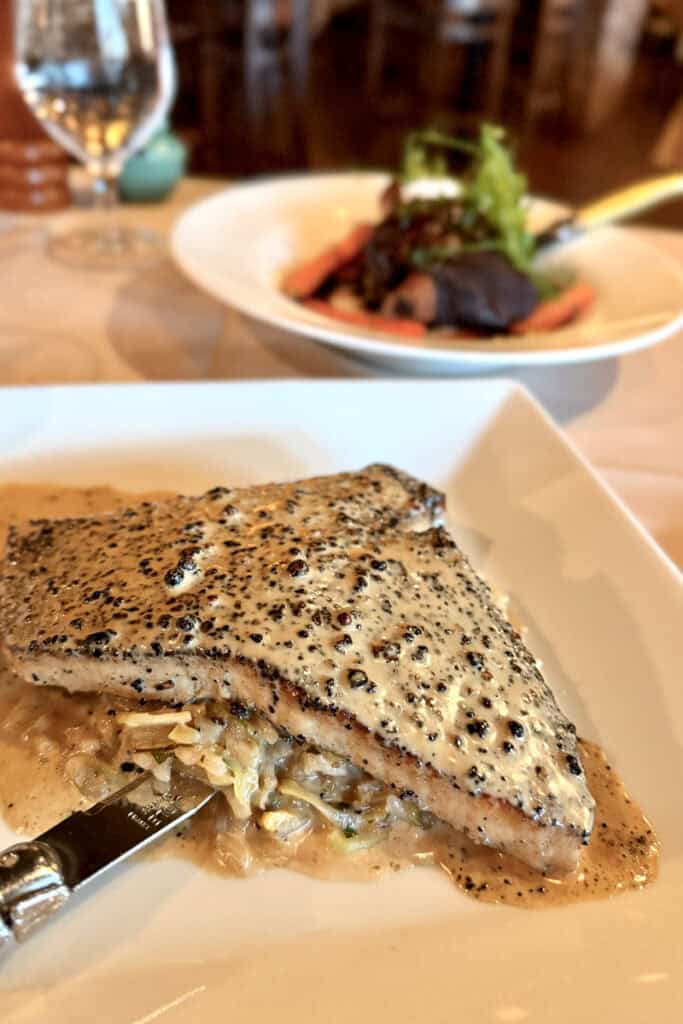 Swordfish with cream sauce and peppercorn topping.