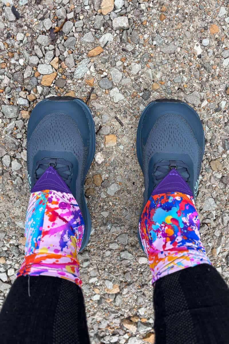 Multi-colored gaiters covering runner's ankles and top of shoes.