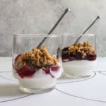 Small glasses holding chia seed parfait, made with layers of yogurt, fruit compote, and granola.