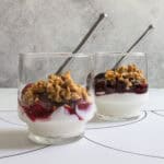 Small glasses holding chia seed parfait, made with layers of yogurt, fruit compote, and granola.