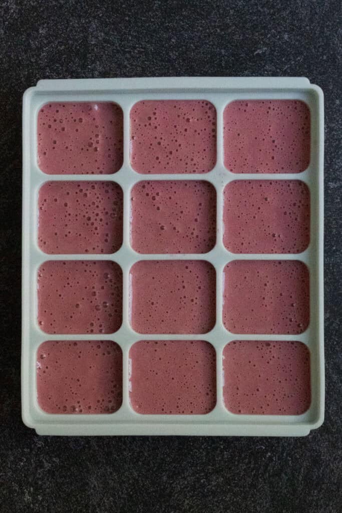 Chocolate cherry smoothie blend poured into silicone molds.