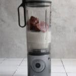 Chocolate cherry smoothie cubes in blender with milk.