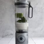 Smoothie cubes and milk in blender.
