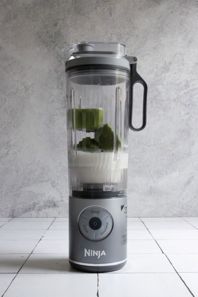 Ingredients for green smoothie cubes shown in blender.