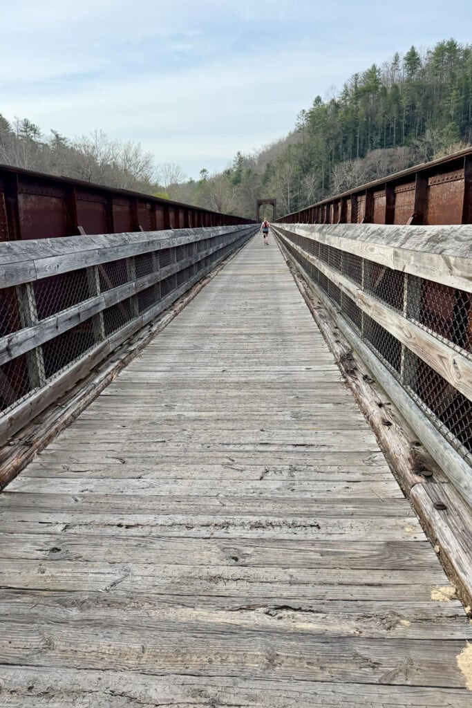 Lengthy wooden bridge with high railings.