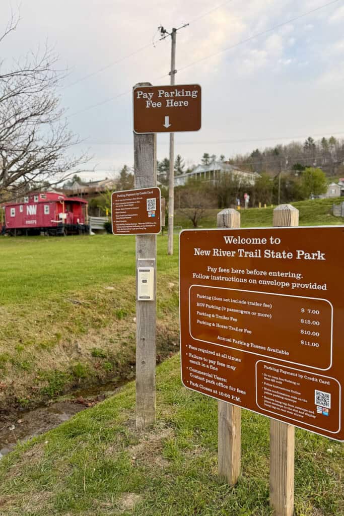 Signs at parking lot of New River State Park with QR code to pay for parking.
