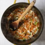 Chopped carrot, onion, celery and herbs in Dutch oven.
